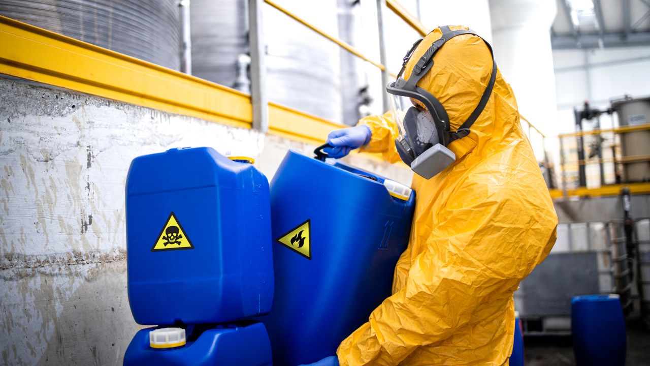 Haz Mat suited man carrying chemicals